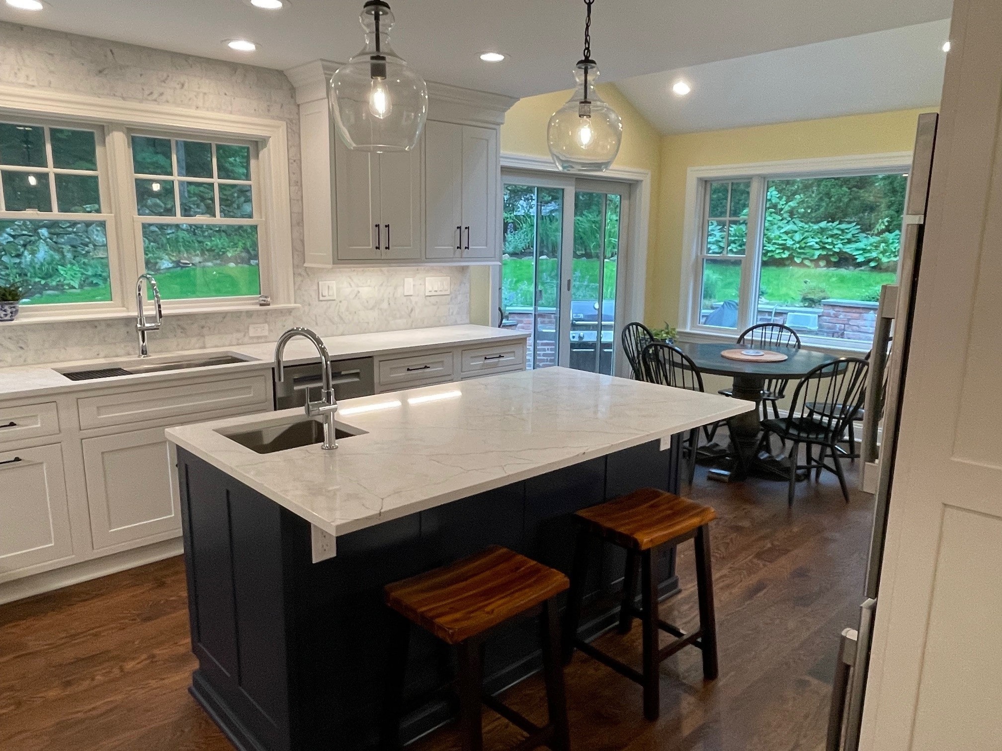 white cabinets with marble countertops and black kitchen island