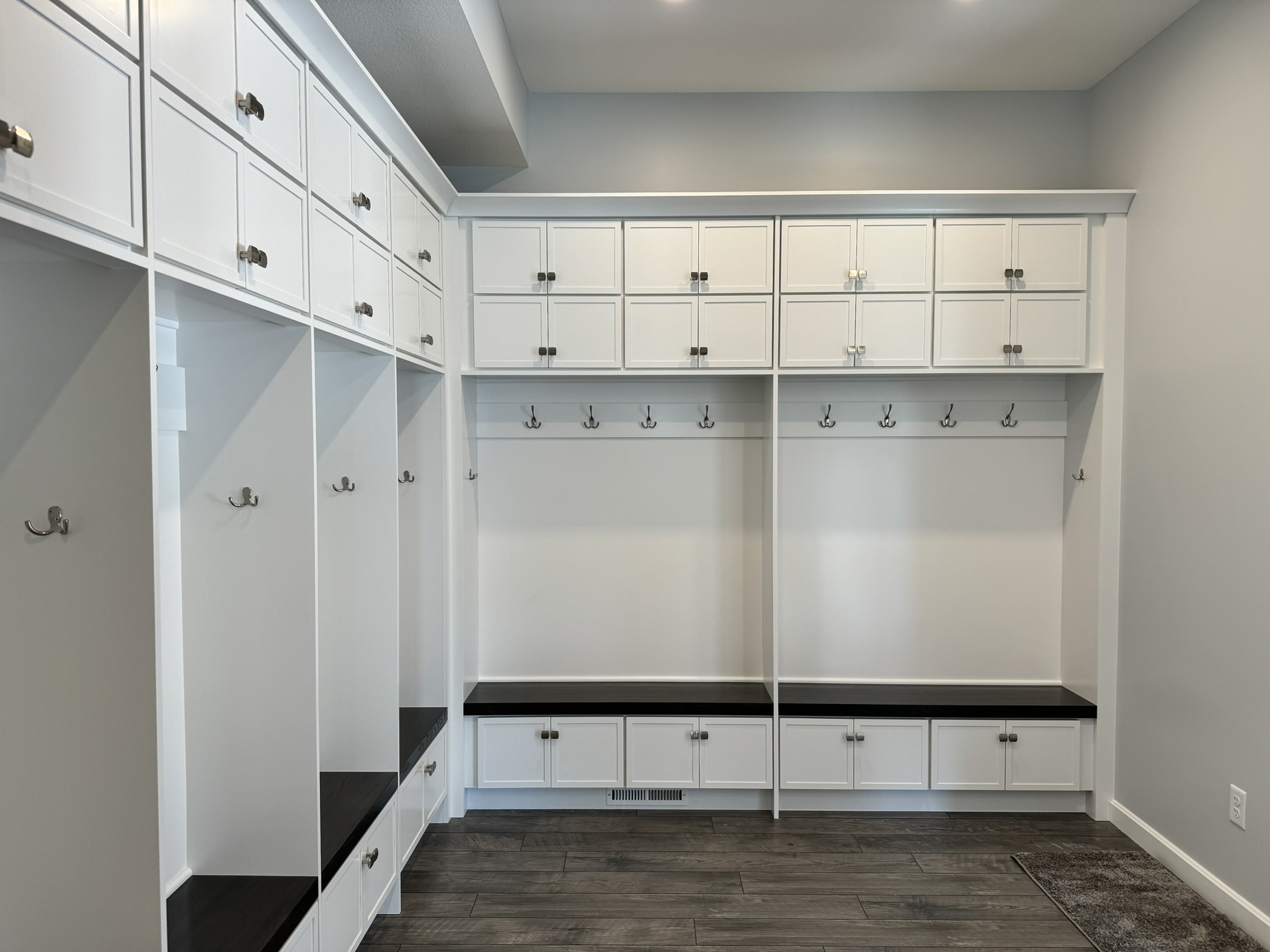 White mudroom cabinets with hooks and benches